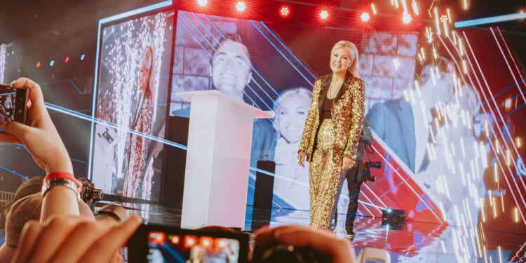Turning Point USA CEO Erika Kirk, widow of right-wing political activist Charlie Kirk, speaks on a stage.
