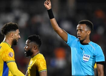 Somali FIFA referee Omar Abdulkadir Artan holds up a card during the Africa Cup of Nations Group F football match between Gabon and Ivory Coast in Marrakech on Dec. 31, 2025.