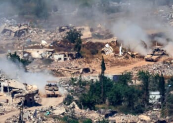 This picture taken from a position in the Upper Galilee in northern Israel, near the Israel-Lebanon border, shows Israeli Merkava tanks driving along a road past destroyed buildings in southern Lebanon on June 17, 2026.
