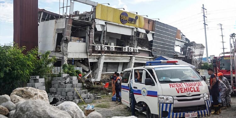 Responders conduct a rescue operation at a collapsed building after a 7.8 magnitude earthquake struck off the southern coast of the Philippines on Monday.