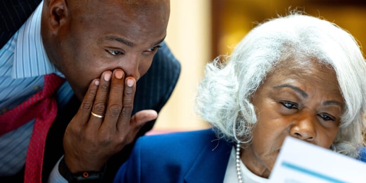 Virginia Sen. Aaron Rouse whispers to Sen. Louise Lucas in the Senate.