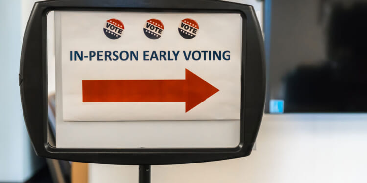 Sign reading "In-Person Early Voting" with a red arrow pointing toward the right.