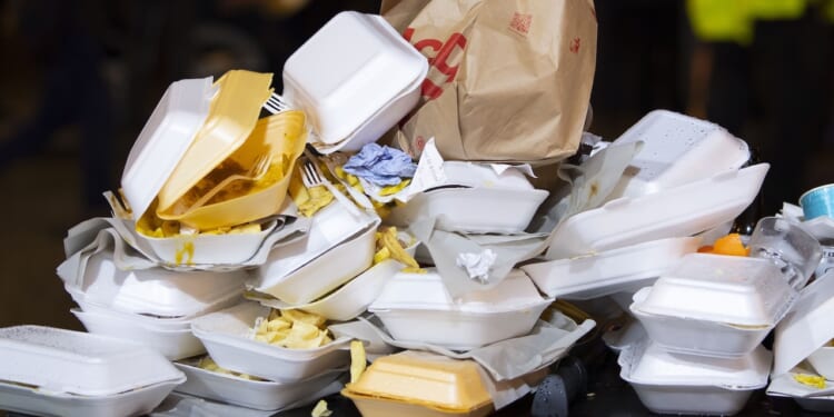 An overflowing bin full of Styrofoam containers is shown.