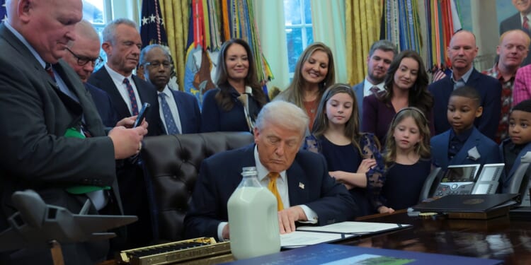 President Donald Trump signs a document during an event with dairy farmers