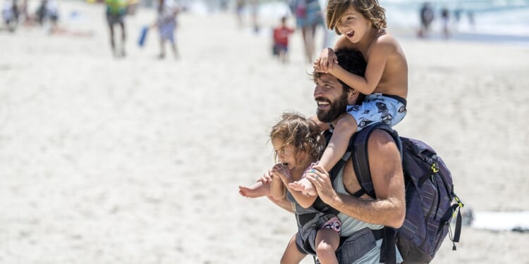 A dad and his two kids on the beach