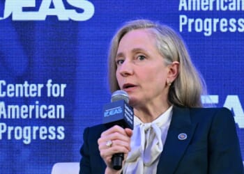 Virginia Governor Abigail Spanberger speaks into a microphone on stage, with a blue backdrop displaying Center for American Progress.
