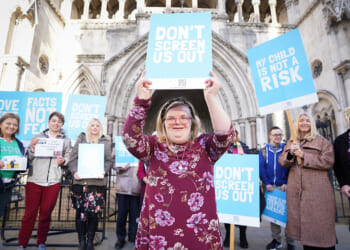 Girl standing with a sign saying, "Don't Screen Us Out."