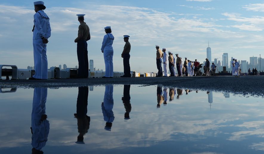 Military personnel stand on the wet flight deck of the USS Kearsarge (LHD-3) anchored in the New York harbor ahead of Sail250, a gathering of tall ships and military ships honoring America's 250th Anniversary, Saturday, July 4, 2026, in New York. (AP Photo/Frank Franklin II)