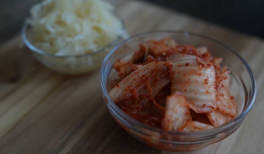 Kimchi and sauerkraut are displayed on a kitchen table in New York on July 10, 2026. (AP Photo/Mary Conlon)