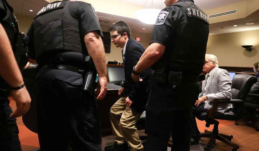 Colt Gray, the 16-year-old convicted in the Apalachee High School shooting, stands to be handcuffed following his sentencing at Barrow County Superior Court in Winder, Ga., on Tuesday, July 28, 2026. (Arvin Temkar/Atlanta Journal-Constitution via AP)
