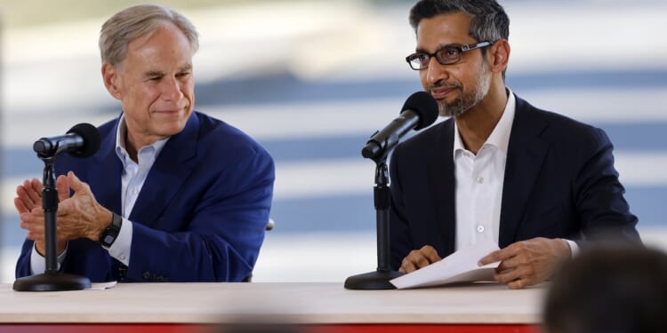 Texas Governor Greg Abbott and Alphabet and Google CEO Sundar Pichai sit at a table with microphones.