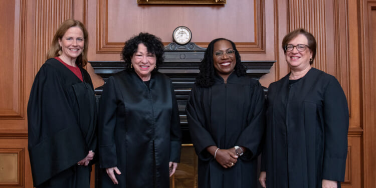 The four female justices pose together, from left to right, Amy Coney Barrett, Sonia Sotomayor, Ketanji Brown Jackson, and Elena Kagan.