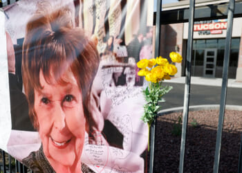 A sign of Nancy Guthrie hangs on the fence of a local Tucson business.