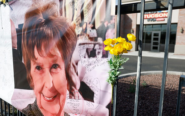 A sign of Nancy Guthrie hangs on the fence of a local Tucson business.