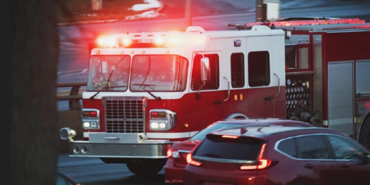 A stock photo of a fire engine with lights flashing.