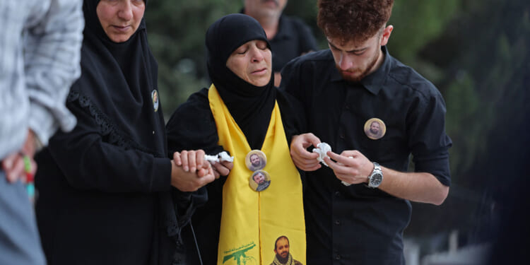 Mourners comfort the mother of Hezbollah fighter Hassan Ali Kallas.