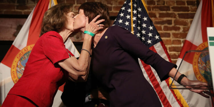 Democratic Florida gubernatorial candidate Gwen Graham (R) is kissed by her mother Adele Graham after conceding the primary to Andrew Gillum on August 28, 2018.