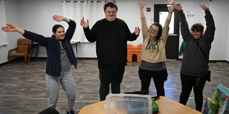 From left, Natalie Baker, a board certified behavior analyst (BCBA), Ethan Ortengren, 18, who has autism, Sayeena Normanleier, a registered behavior technician (RBT), and Dezart Stover, a behavior technician (BT), watch a roller coaster video to help Ethan with movement during therapy at Seven Dimensions Behavioral Health in Evergreen, Colorado, on March 16, 2026.