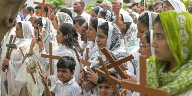 Christians hold up crosses in Amritsar, India, during a Good Friday procession on April 3, 2026.