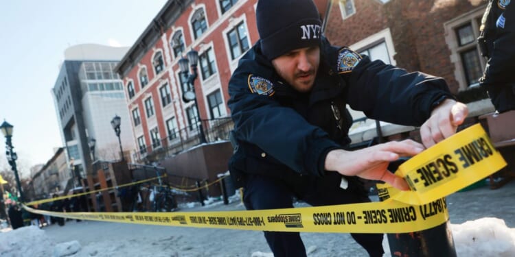 Police put up crime scene tape as members of the Hasidic Jewish community gather outside of the Chabad Lubavitch world headquarters, where a man was arrested Wednesday evening after repeatedly crashing his car into a door of the building on Jan. 29, 2026, in New York City.