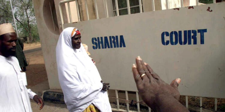 Safiya Husseini, in company of her brother Sanni, arrives at the Sokoto State Sharia Court of Appeal, 18 March, 2002 to appeal against the judgement of an Islamic court which sentenced her to death by stoning.