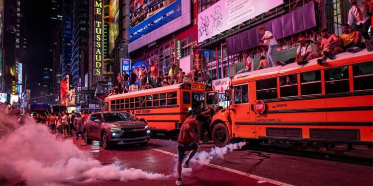 A person kicks a smoke canister as New York Knicks fans celebrate their win against San Antonio Spurs in Game 5 of the NBA Finals June 14 in Times Square in New York City. One exuberant fan reportedly set fire to a school bus.