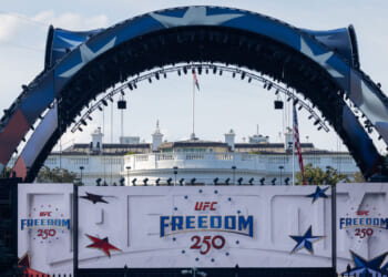 Large decorated stage with UFC Freedom 250 banners in front of the White House, featuring stars and patriotic colors.