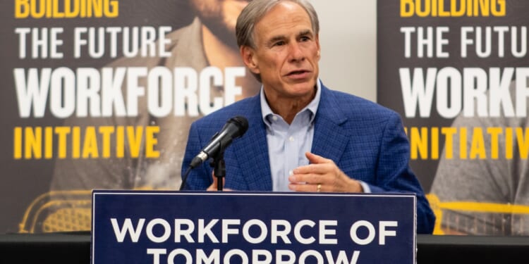 Gov. Greg Abbott in a blue blazer speaks at a podium labeled “Workforce of Tomorrow,” with banners behind him reading “Building the Future Workforce Initiative.”