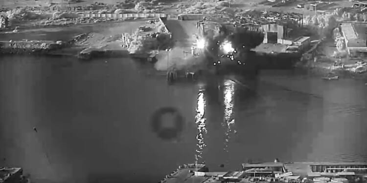 In this handout footage provided by the U.S Department of War, U.S. sea drones strike a submarine and a ship maintenance facility on July 13, 2026, in an undisclosed area of Iran.