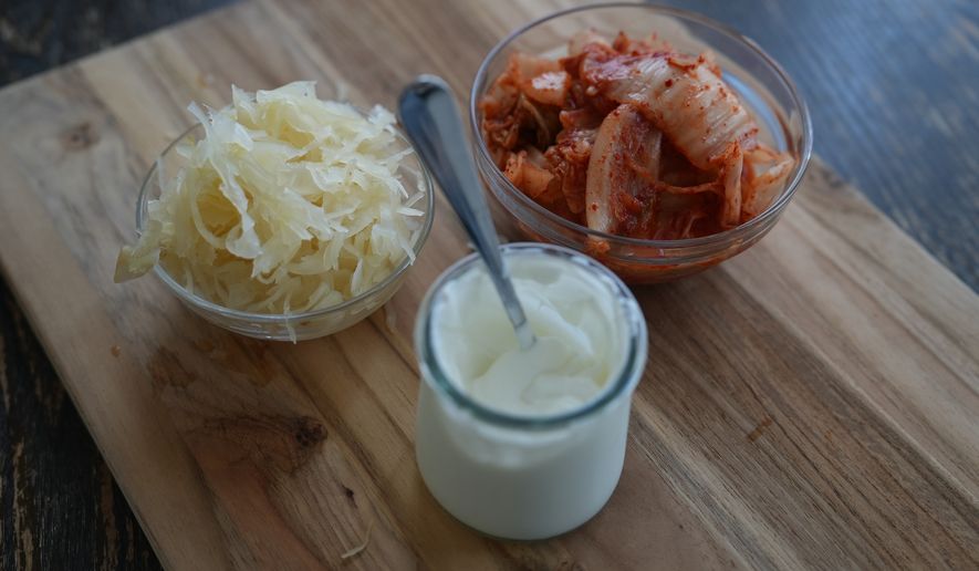 Kimchi, sauerkraut and yogurt are displayed on a kitchen table in New York on July 10, 2026. (AP Photo/Mary Conlon)