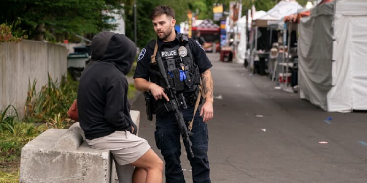 A police officer talks to people while responding to a shooting at the Bite of Seattle food festival on July 26, 2026 in Seattle, Washington.