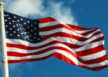 The American flag waves in the wind on a bright afternoon.