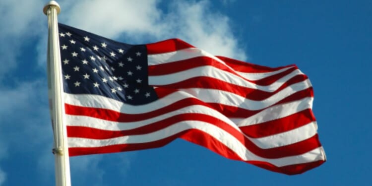 The American flag waves in the wind on a bright afternoon.