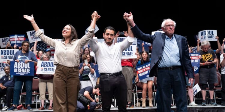 Rep. Alexandria Ocasio-Cortez, Michigan Democratic candidate for Senate Abdul El-Sayed, and Sen. Bernie Sanders greet the crowd after El-Sayed spoke at The People v. The Powerful rally at the Detroit Opera House on July 18 in Detroit, Michigan.