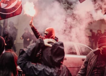 A person is holding a red smoke bomb during an anti-fascist demonstration held to mark the 13th anniversary of the death in 2013 of activist Clement Meric in Paris, France, on June 6, 2026.