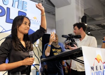 Democratic congressional candidate Melat Kiros with her fist raised