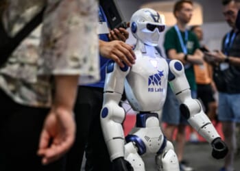 A robot stands amongst a crowd at the AI for Good Global Summit on July 7, 2026.
