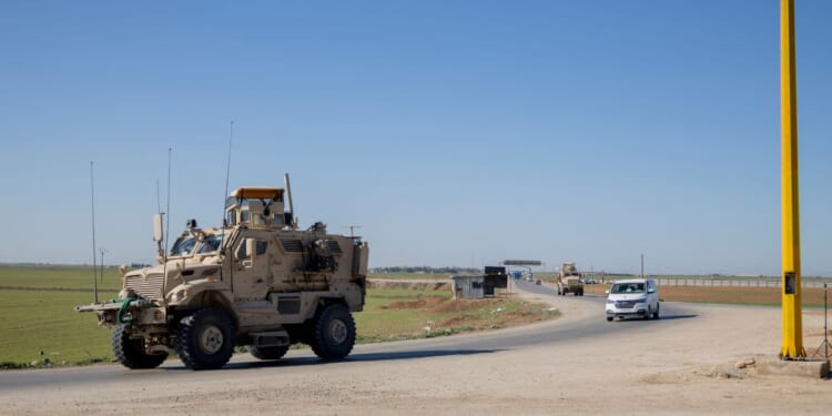 A U.S. military mine-resistant ambush protected armored fighting vehicle drives along a highway outside Qamishli in Syria's northeastern Hasakah province on Feb. 22, 2026.