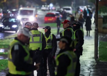 Police officers patrol the street as fireworks go off in the distance on Nov. 5, 2025, in Edinburgh, Scotland.