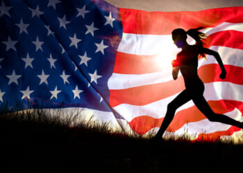 silhouette of a woman running up a small hill with graphic of American flag behind her, with sun shining through the flag's stripes.