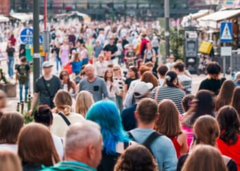 People walk on a busy street during the day.