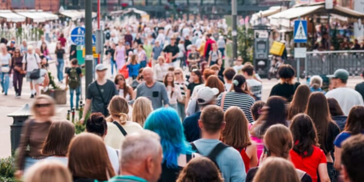 People walk on a busy street during the day.