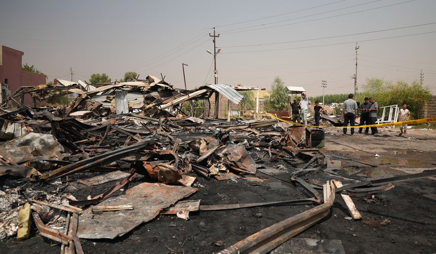 Iraqis inspect damaged structures at the site of an airstrike on a Popular Mobilization Forces base in Mosul, Iraq, Wednesday, July 29, 2026. (AP Photo/Farid Abdulwahed)
