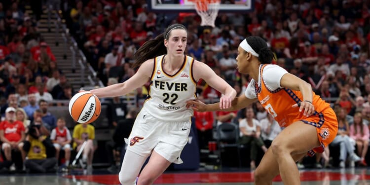 Caitlin Clark of the Indiana Fever dribbles the ball while defended by Nell Angloma of the Connecticut Sun at Gainbridge Fieldhouse on July 22, 2026, in Indianapolis, Indiana.