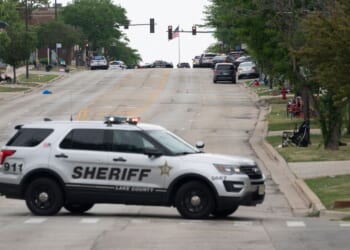 Law enforcement officers patrol the scene of the Fourth of July parade shooting in Highland Park, Illinois, on July 4, 2022.
