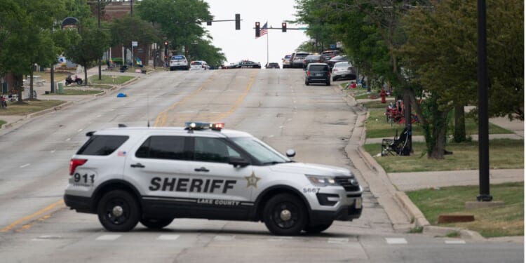 Law enforcement officers patrol the scene of the Fourth of July parade shooting in Highland Park, Illinois, on July 4, 2022.