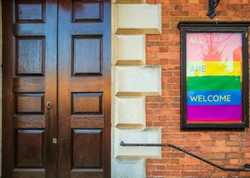 An LGBT-affirming sign posted outside the front door to a Christian church.
