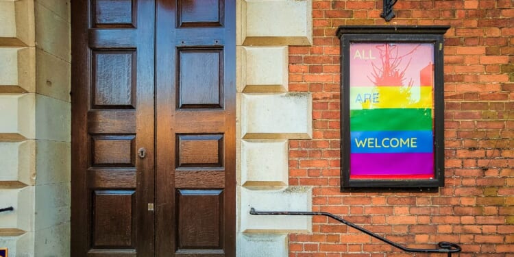 An LGBT-affirming sign posted outside the front door to a Christian church.