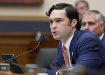 U.S. Rep. Brandon Gill leans forward in a blue suit and red tie.