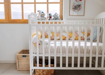 A baby crib in a modern cozy bedroom.